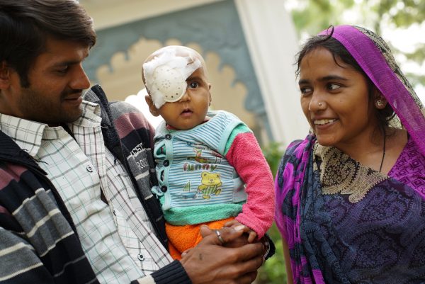Parents with young child after eye surgery