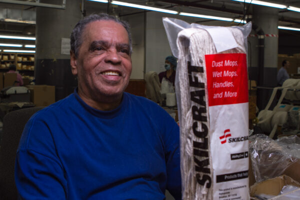 Man smiles while holding mop