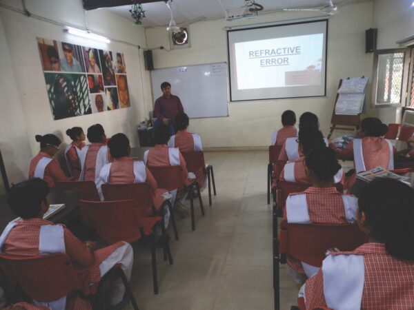 A classroom of AOP students being lectured by an instructor utilizing a projector