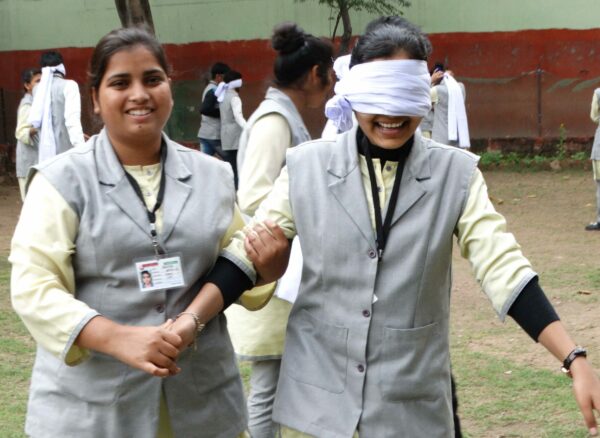 Female AOP student leads another who is blindfolded for training purposes